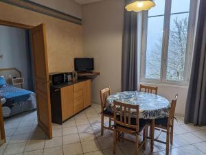 ein Zimmer mit Tisch und Stühlen und ein Schlafzimmer in der Unterkunft Villa saint hubert in Bourbonne-les-Bains