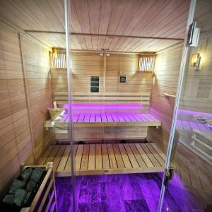 a sauna with purple lighting in a wooden room at Pensiunea Casa-Stefanel in Sadova