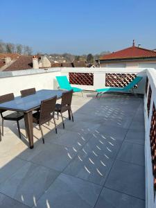 eine Terrasse mit einem Tisch und Stühlen auf dem Dach in der Unterkunft Largo in Bourbonne-les-Bains