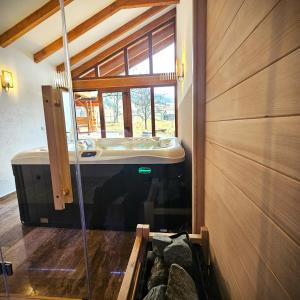 a bathroom with a tub in a room with a window at Pensiunea Casa-Stefanel in Sadova