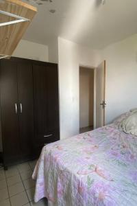 a bedroom with a bed and a wooden cabinet at Apartamentocamboinhapraiapiscinaeconforto in Cabedelo +8 photos