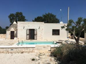uma casa com uma piscina em frente em Villa Trullo Cristi em Alberobello