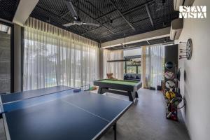 a ping pong table in a room with a pool table at StayVista at Acasa with Lawn in Alibaug