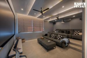 a living room with a couch and a tv at StayVista at Acasa with Lawn in Alibaug