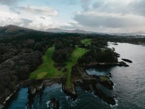 an aerial view of a golf course next to the water at Dreambox South Kerry in Sneem