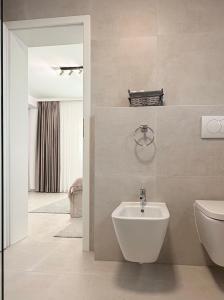 a bathroom with a sink and a toilet and a mirror at Express Apartments Suceava in Ipoteşti +45 photos