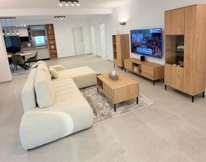 a living room with a white couch and a tv at Express Apartments Suceava in Ipoteşti