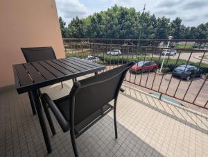 un tavolo e una sedia su un balcone con posto auto di Le bourbon a Bourbonne-les-Bains