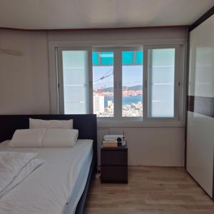 Un pat sau paturi într-o cameră la Busan Style, Busan Yeongdo, Full Ocean View, Rooftop Camping Sensation, Remodeling, Beam Projector, Parking Support,3 Rooms