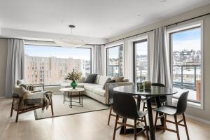 a living room with a couch and a table at Premium Penthouse in Tromsø - Northern lights, City, Sea & Mountain view in Hjorten