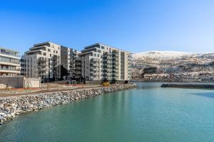 a body of water with buildings in the background at Premium Penthouse in Tromsø - Northern lights, City, Sea & Mountain view in Hjorten