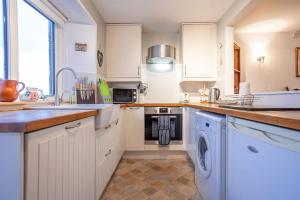 een keuken met witte kasten, een spoelbak en een vaatwasser bij West End No 18 - St Monans in Saint Monance +29 foto's