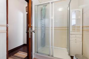 een douche met een glazen deur in een badkamer bij Casa Campo e Mar in Azenhas +16 foto's