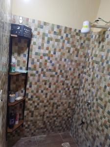 y baño con ducha y pared de azulejos. en Ulises House, en Luque 6 fotos más