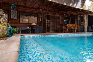 a swimming pool in front of a house at Diar Abou Habibi in Tozeur