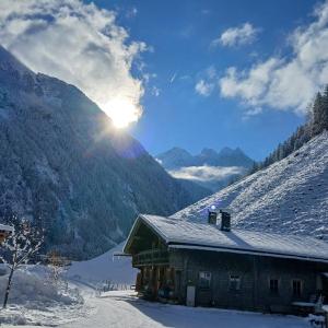 a cabin in the mountains with snow on the ground at Alpenchalet Lengau in Dornauberg