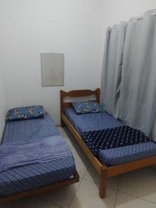 2 letti con lenzuola blu in una stanza di Paradise a Saquarema