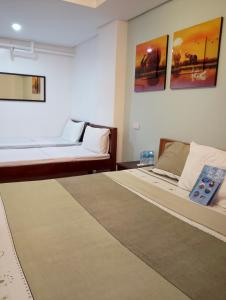 a bedroom with two beds and a rug at Aqua Travel Lodge in El Nido