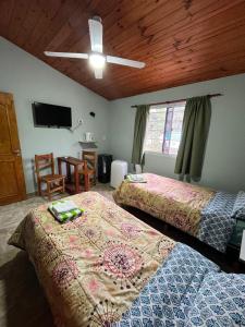 a bedroom with two beds and a flat screen tv at Hotel Complejo Del Carmen San Bernardo in San Bernardo