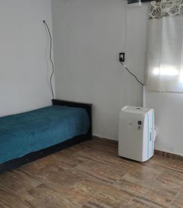 a small room with a bed and a refrigerator at Casa Marty 2 in Ezeiza