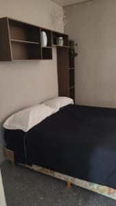 a bed in a room with a black bed frame at Casa Marty 2 in Ezeiza