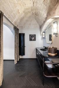 Dimora San Nicola Charming Suite في كونفيرسانو: حمام مزود بحوض ومِرآة