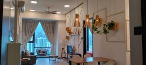 un salon avec une table, des chaises et des fenêtres dans l'établissement Opus Residences Warisan Merdeka by C&C Fortune, à Kuala Lumpur