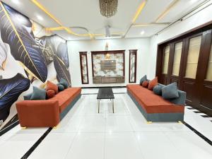 a living room with two couches and a table at Sky Lodge Guest House in Islamabad