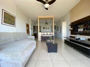 Una sala de estar con un sofá y un ventilador de techo. en Apto Confortável p/ até 9P, 50mts do mar Piçarras, en Piçarras 4 fotos más