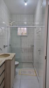 a bathroom with a shower with a sink and a toilet at Casa para 7 Pessoas em Bombas 600 m da Praia in Bombinhas +16 photos
