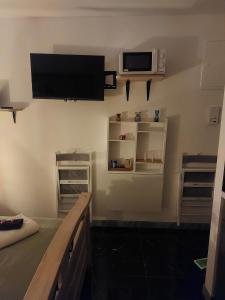 a living room with a tv and a kitchen with a counter at Beautiful small Apartment El silencio in Zürich