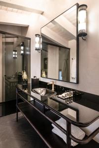 Dimora San Nicola Charming Suite في كونفيرسانو: حمام مع حوض ومرآة كبيرة +48 صورة