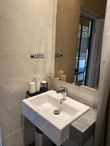 a bathroom with a white sink and a mirror at ABE Hotel & Convention in Siborongborong +81 photos