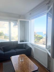 ein Wohnzimmer mit Sofa und Tisch in der Unterkunft Maison en bord de mer in Concarneau