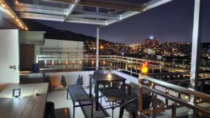 a balcony with chairs and a table and a city skyline at BinsHeim HBC - Seoul's Aesthetic Stay with the best Night view Rooftop in Seoul