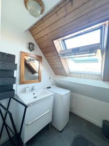 ein Badezimmer mit Waschbecken und Oberlicht in der Unterkunft Maison en bord de mer in Concarneau