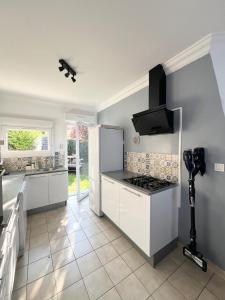 eine Küche mit weißen Schränken und einem Herd in der Unterkunft Maison en bord de mer in Concarneau