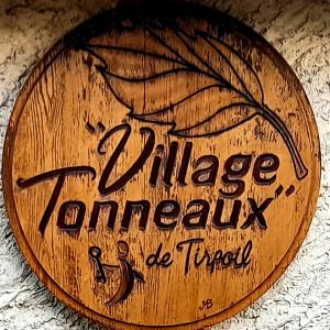 " village tonneaux de tirpoil " في Montilliers: لافتة خشبية مكتوب عليها "وكالة قرية أورانج"