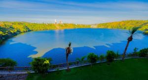 a large blue lake with palm trees in a field at Noora Resort 