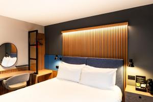 a hotel room with a bed and a chair at Village Hotel Manchester Ashton in Ashton under Lyne +34 photos