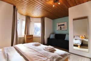 a bedroom with a large bed and a mirror at Miraflor Carmen - Arosa Holiday in Arosa