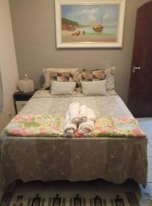a bedroom with a bed with towels on it at Hospedagem domiciliar in Guarujá