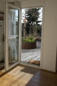 eine offene Glasschiebetür mit Blick auf einen Hof in der Unterkunft Filipponi's Träumli in Rüthi