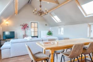 a living room with a table and a couch at Cozy apartment with stunning view over the fields in De Haan