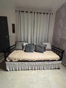 a bed with pillows on it in a room at Refúgio Pérola Capixaba in Marataizes