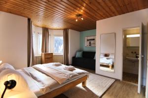 a bedroom with a bed and a couch in it at Miraflor Carmen - Arosa Holiday in Arosa +17 photos