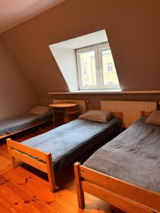 Zimmer im Dachgeschoss mit 2 Betten und einem Fenster in der Unterkunft Hostel Grudziadz in Graudenz + 8 Fotos