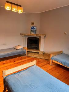 ein Wohnzimmer mit 2 Betten und einem Kamin in der Unterkunft Hostel Grudziadz in Graudenz