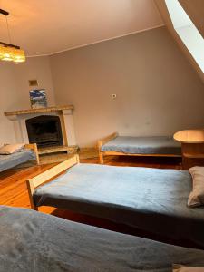 ein Wohnzimmer mit 2 Betten und einem Kamin in der Unterkunft Hostel Grudziadz in Graudenz