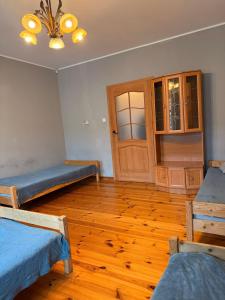 ein Zimmer mit drei Betten und Holzboden in der Unterkunft Hostel Grudziadz in Graudenz